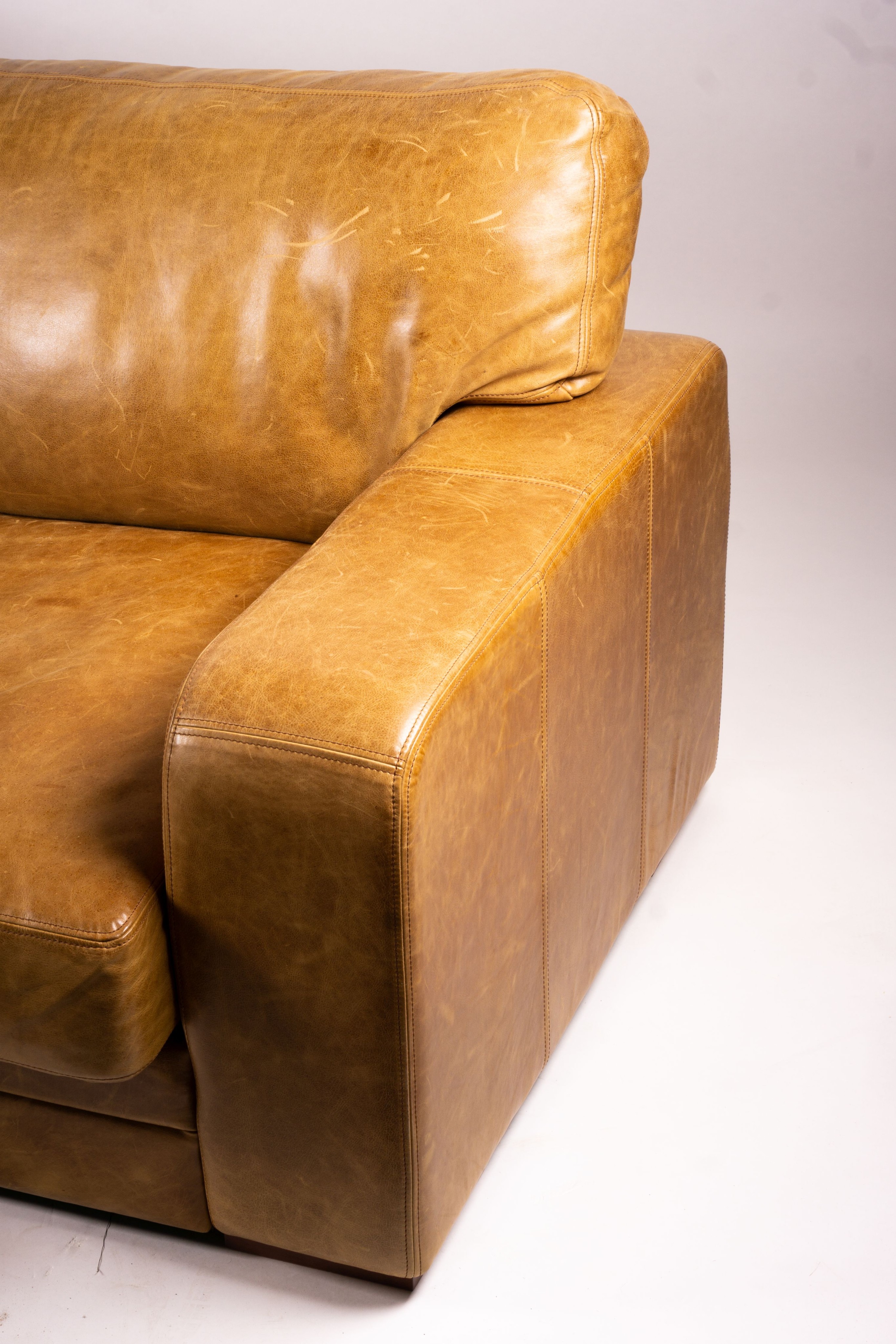 A pair of contemporary tan leather settees, length 200cm, depth 100cm, height 94cm